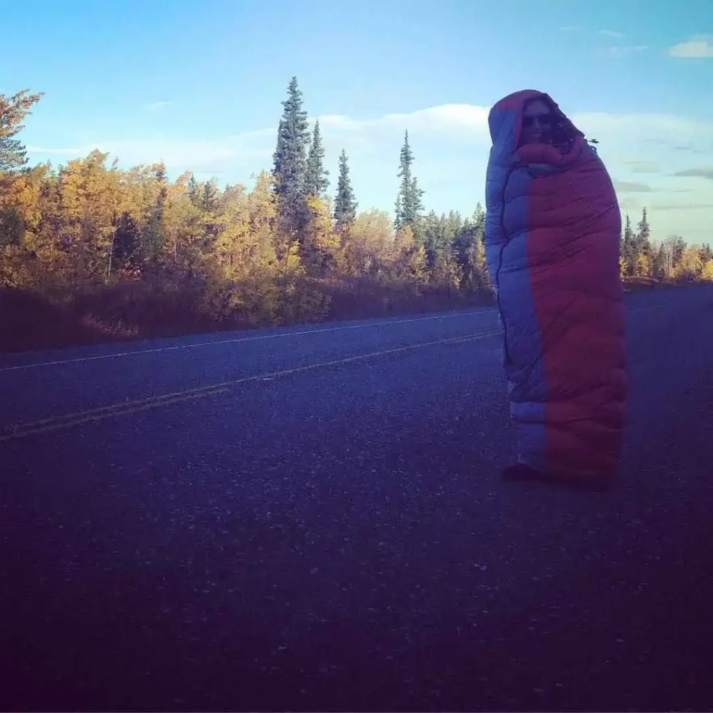 hunter with sleeping bag on roadside